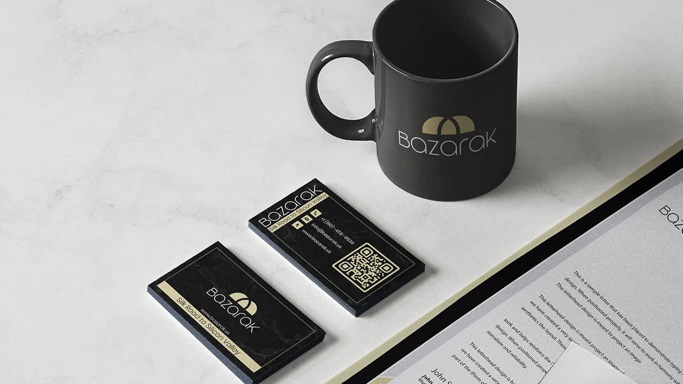 Branded mug and gold-foil business cards styled on marble.